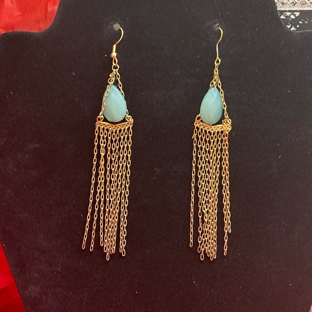 Long gold tone earrings with green stones